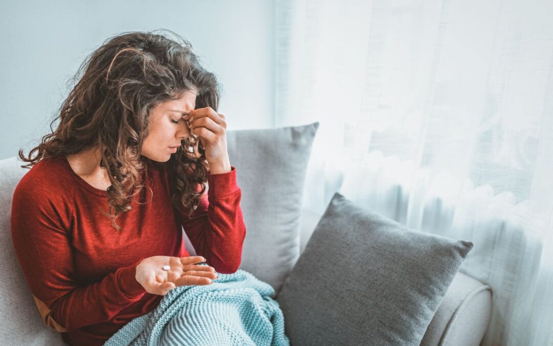 Woman with a migraine, considering acupuncture as an alternative to painkillers